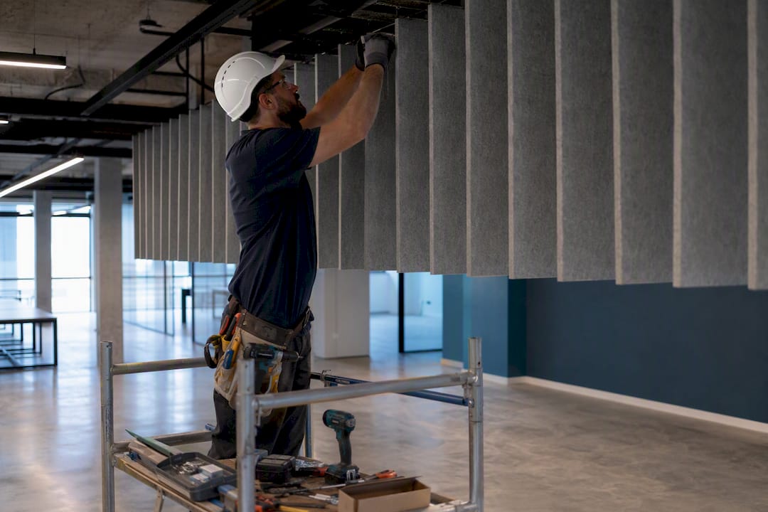 Person installing acoustic ceiling baffles
