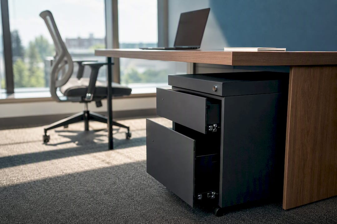 Under-desk pedestal drawer partially open in office