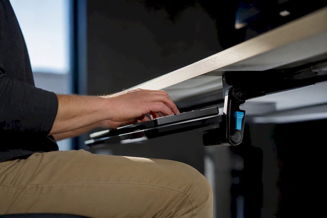 Hands adjusting an ergonomic keyboard tray